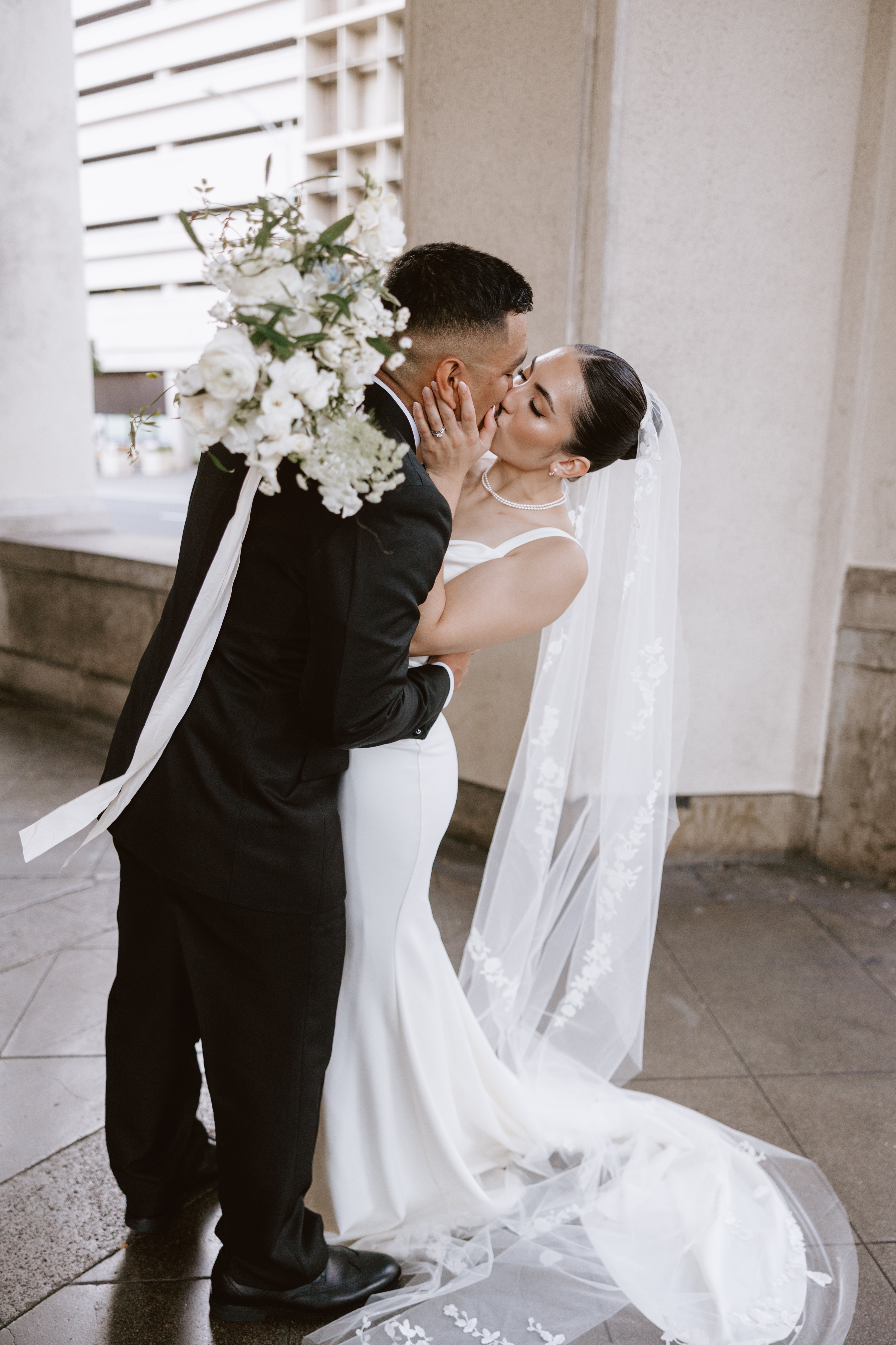 Wedding Couple Posing for a photo, kissing each other.