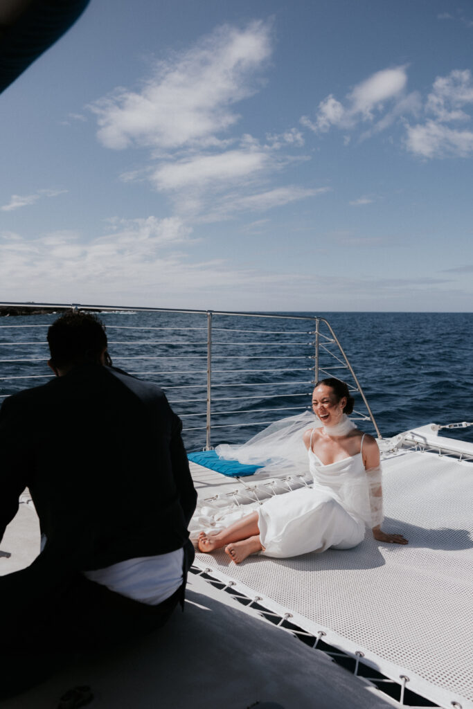 A wedding couple enjoying a themed post-wedding catamaran boat ride with friends.
